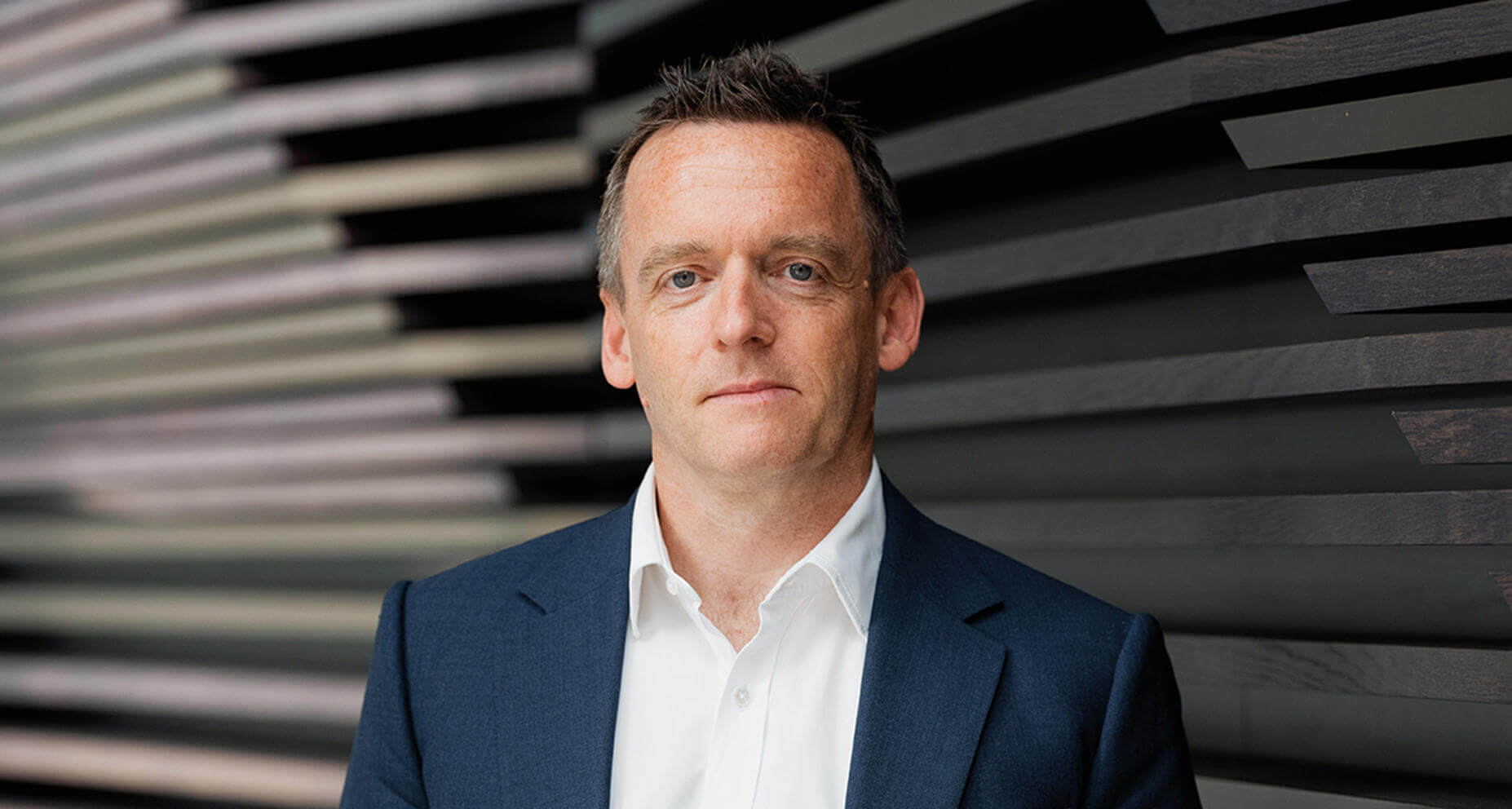 A man wearing a blue jacket and a white shirt