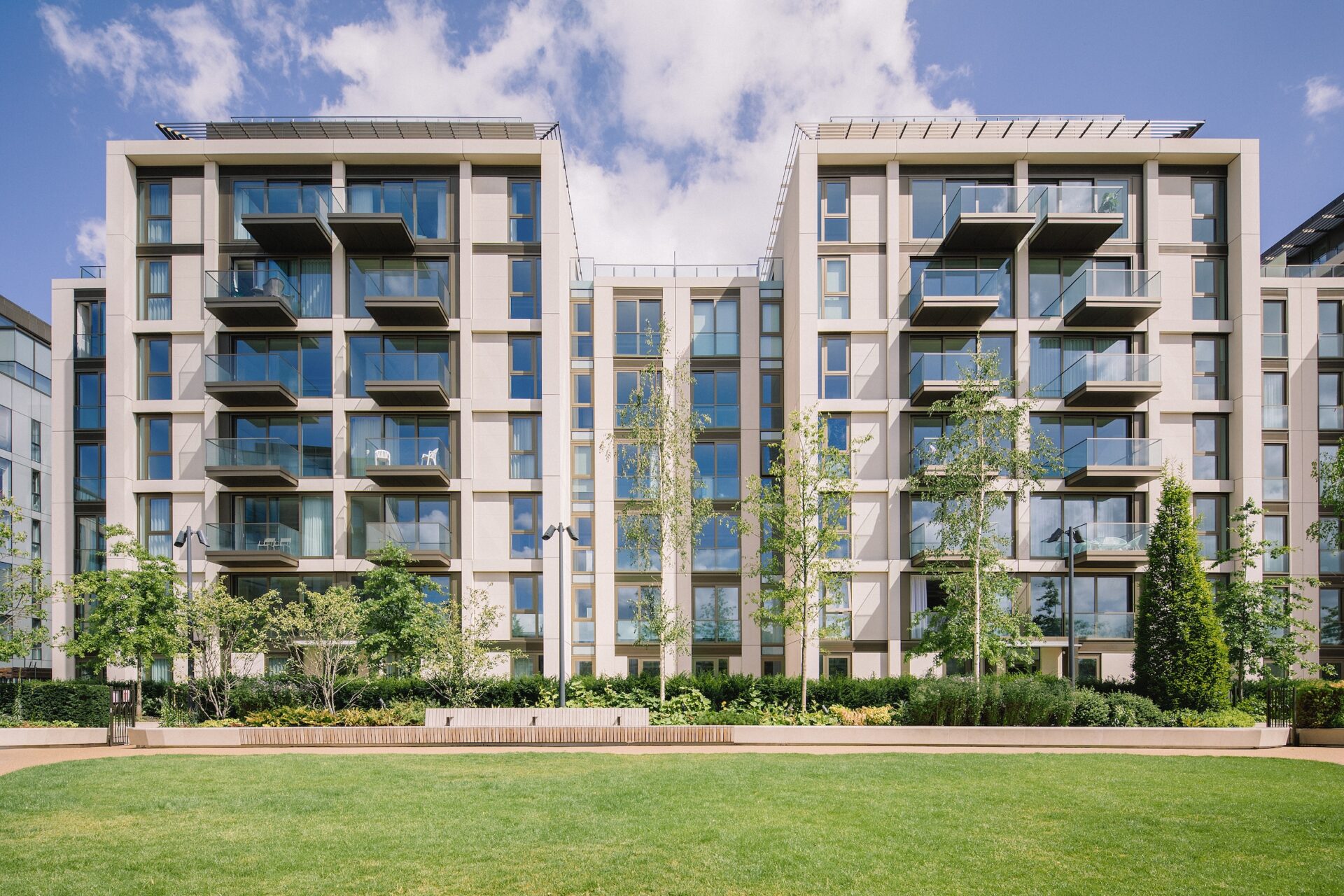 Two blocks of modern low rise buildings featuring balconies and green space to the front at Lillie Square
