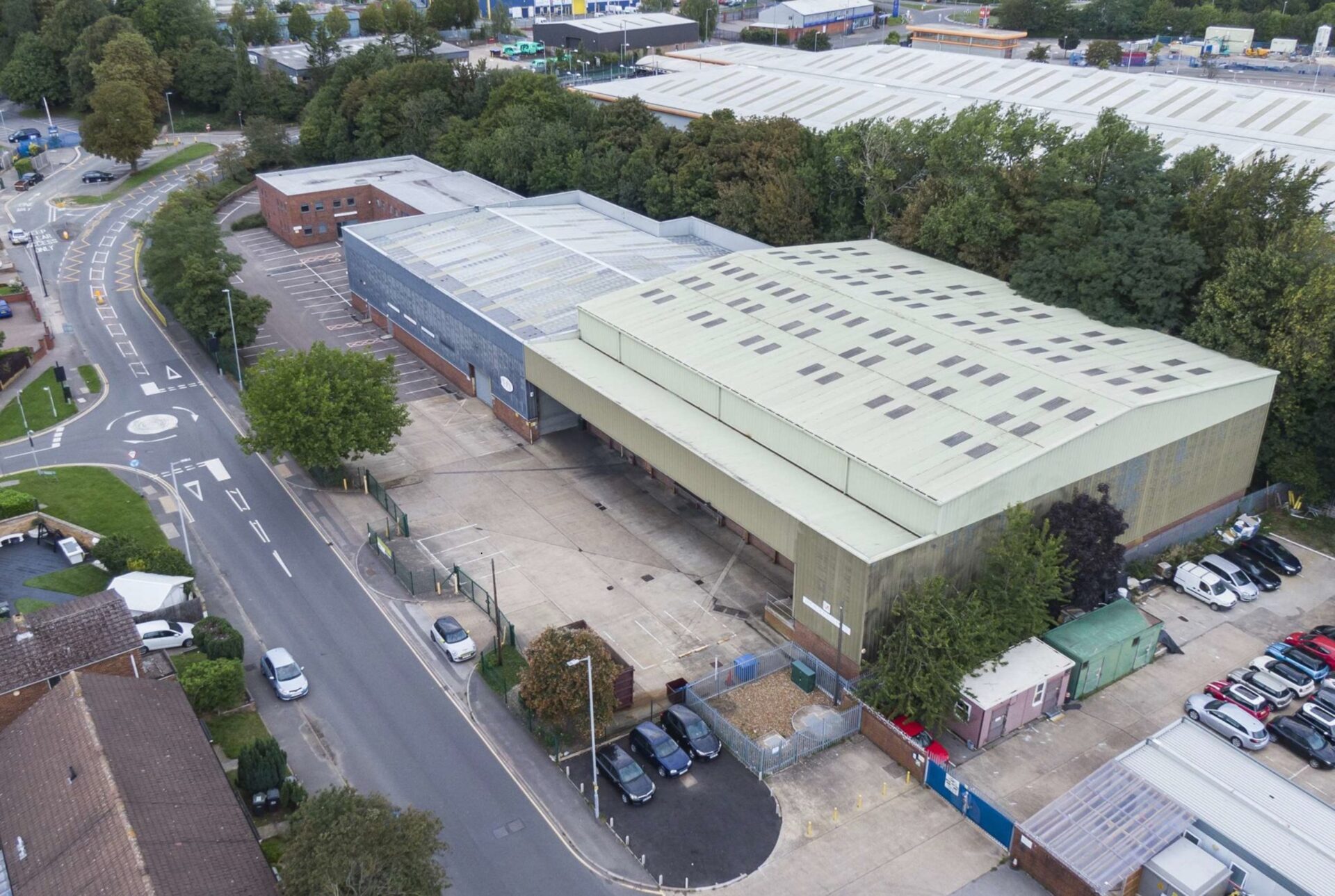 Aerial view of an old industrial building with a main road running alongside
