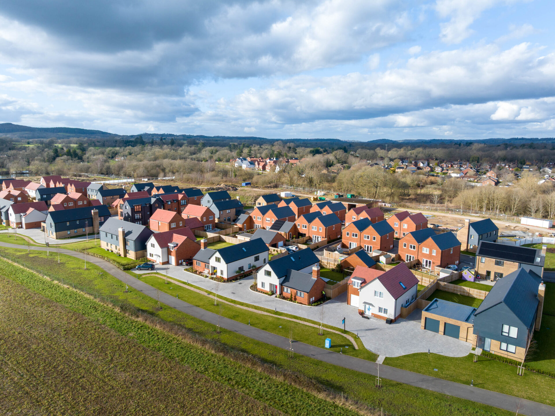 Aerial view CGI of a new housing development in Cranleigh featuring lots of different house sizes and types