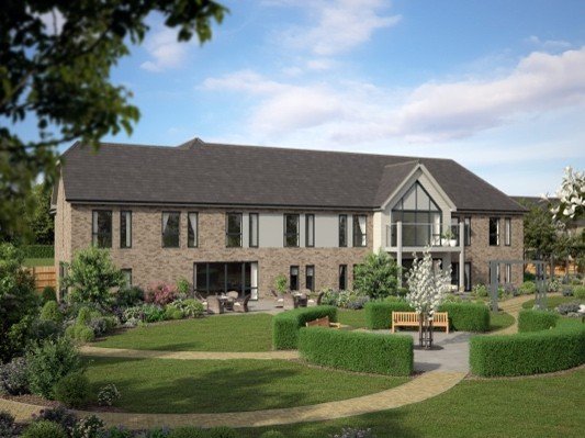 Modern low rise care home featuring landscaped lawns and gardens to the front of the property