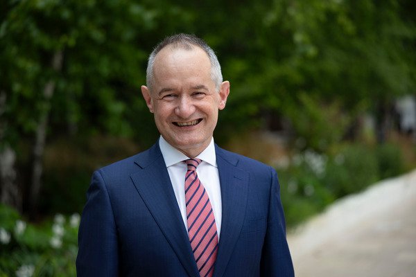 David Allen Mace CFO wearing a dark blue suit, a blue shirt and a red tie