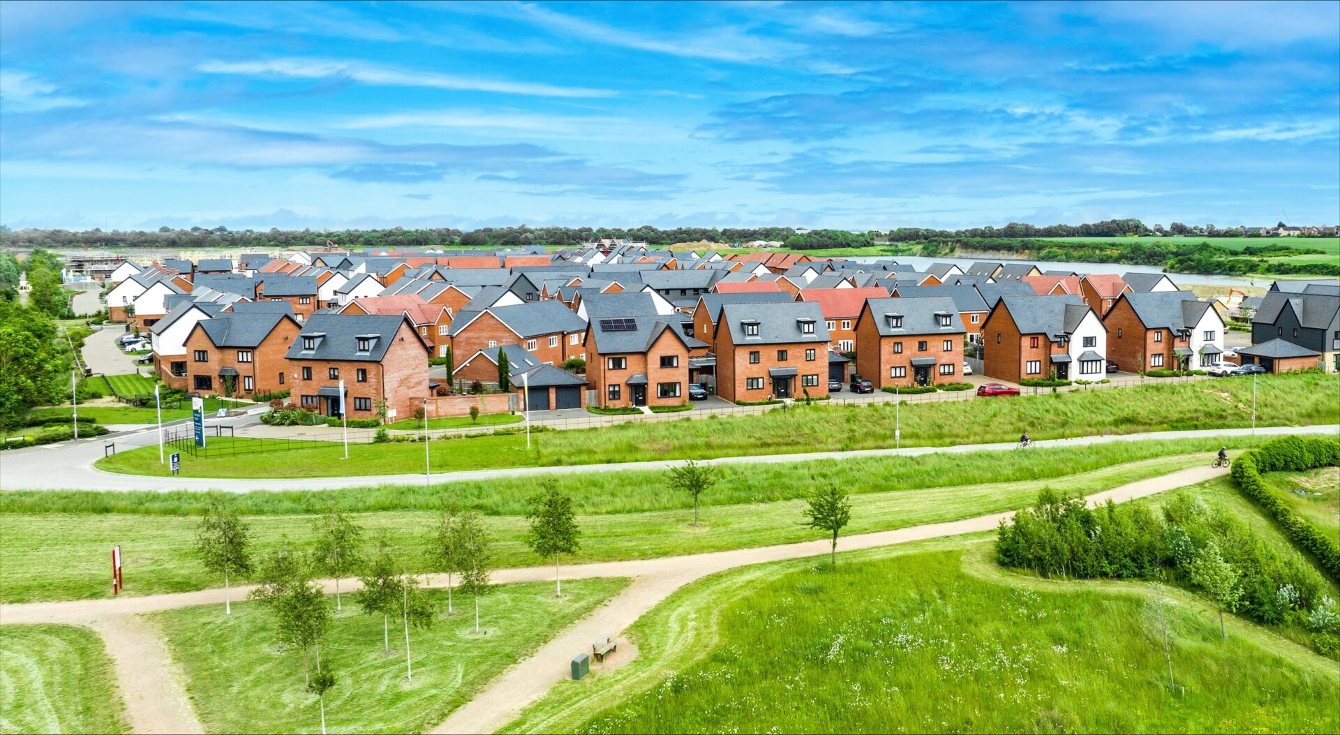Aerial view of a housing development with lots of green fields in front