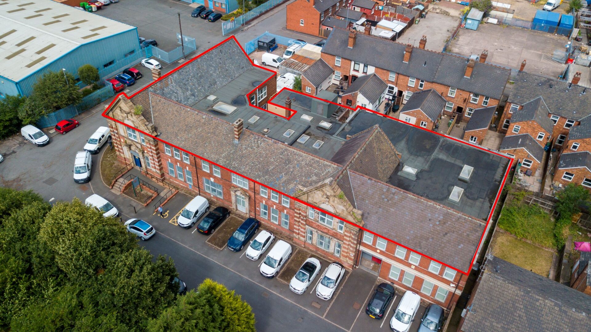 Aerial view of a brick built Victorian building with a red line highlighting the extent of the site