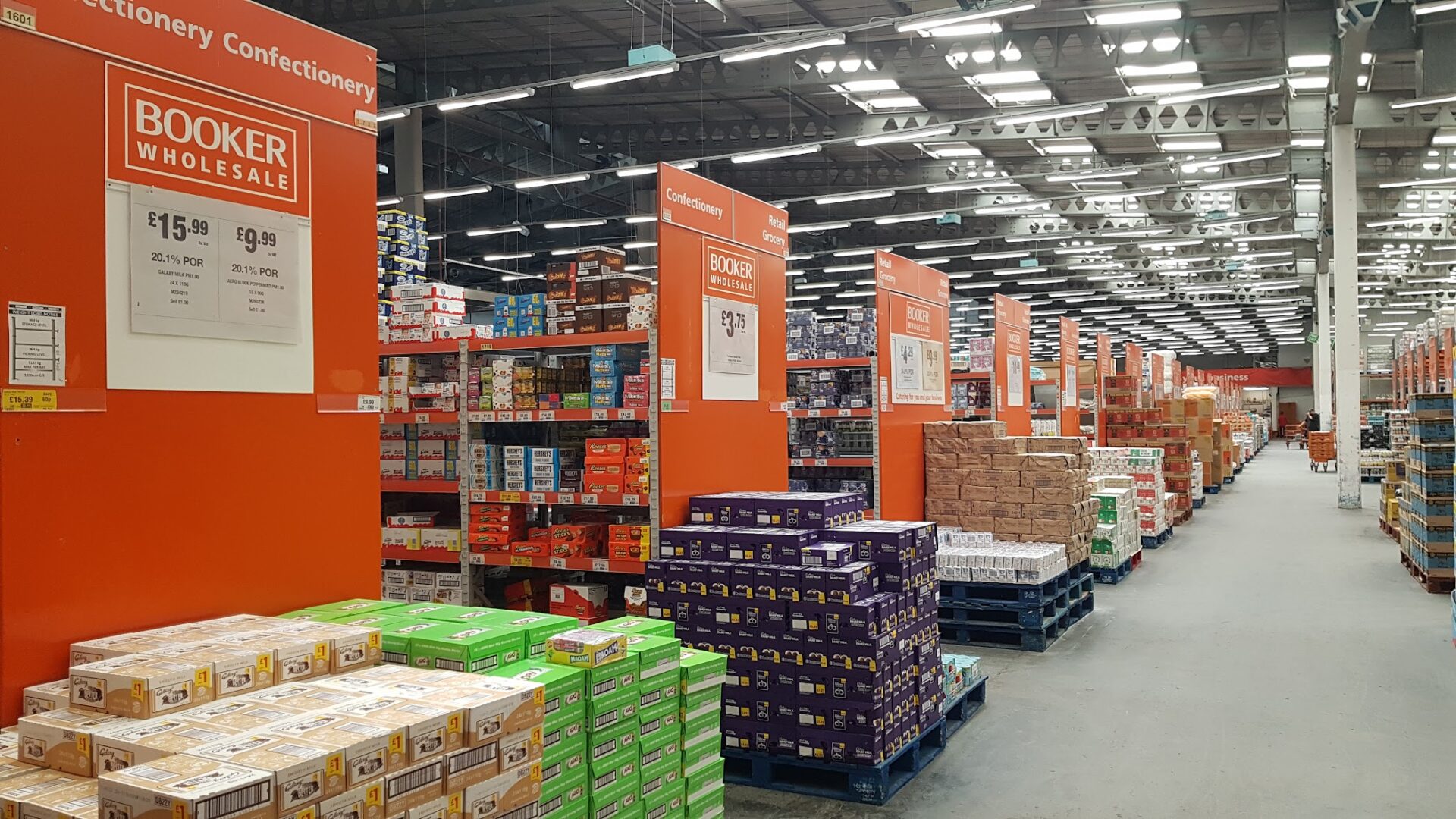 Interior of a Booker wholesale unit featuring lots of food products stacked on shelves and pallets