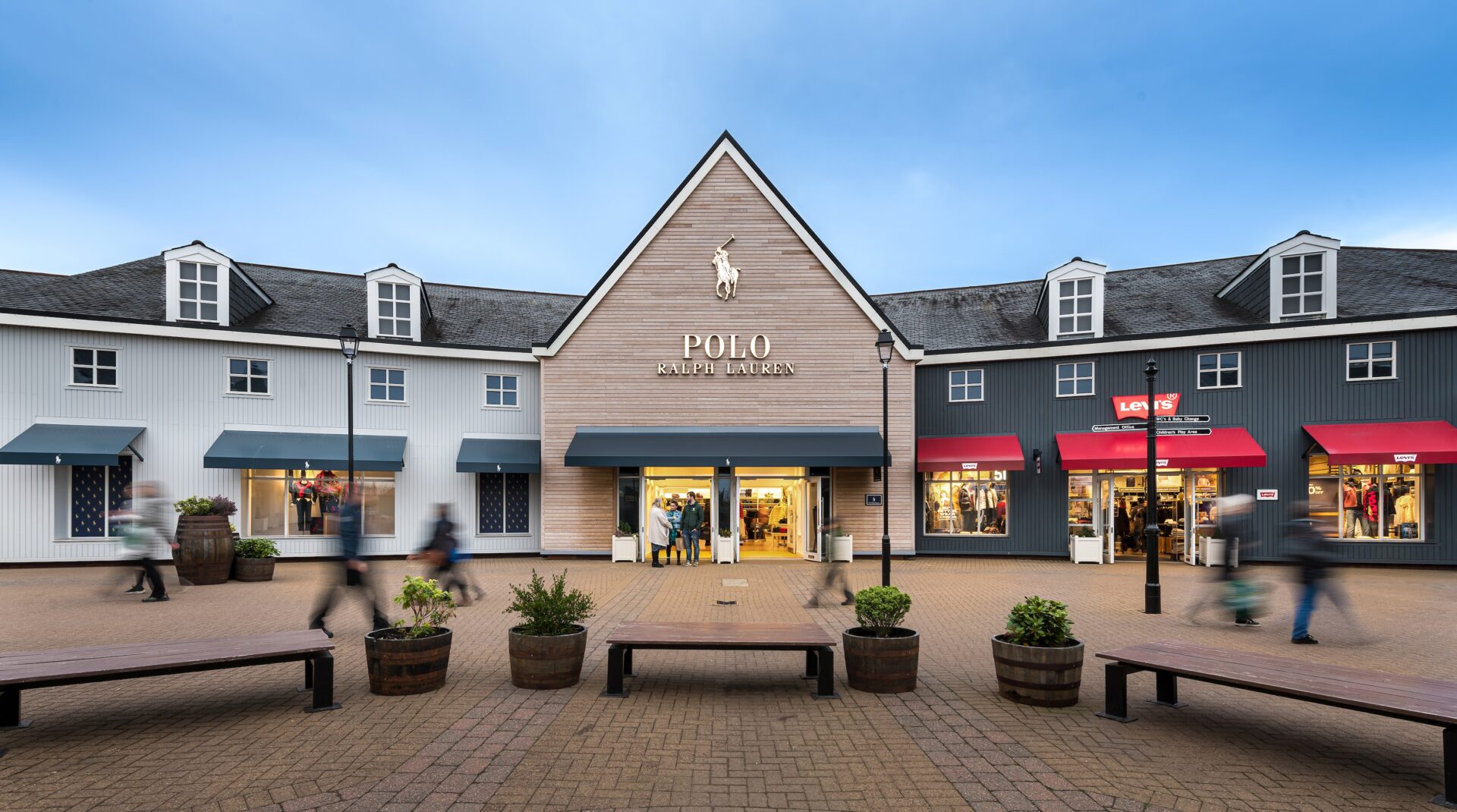 Low rise wooden cladded buildings with a Polo Ralph Lauren store in the middle