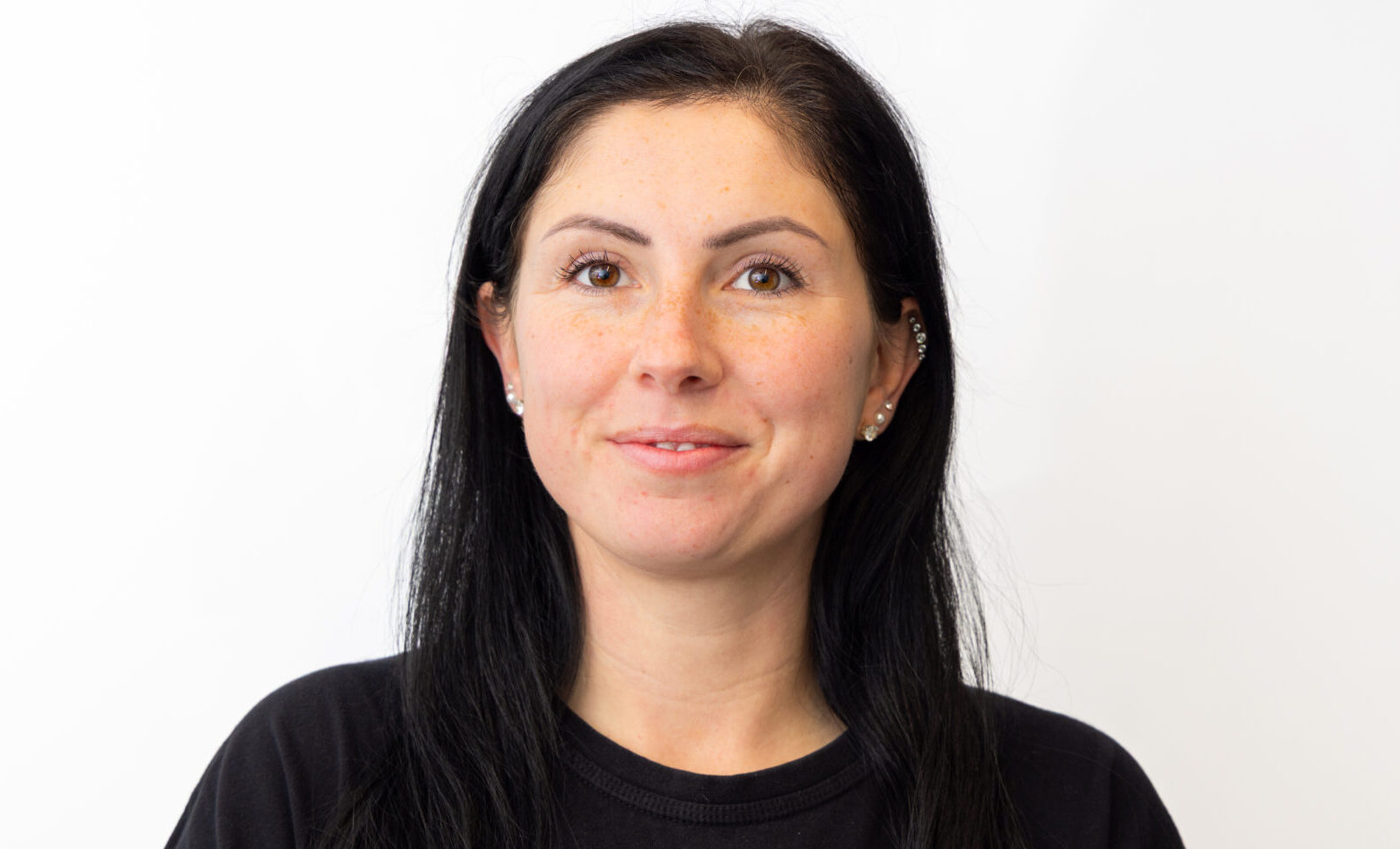 A woman with long dark hair wearing a dark shirt