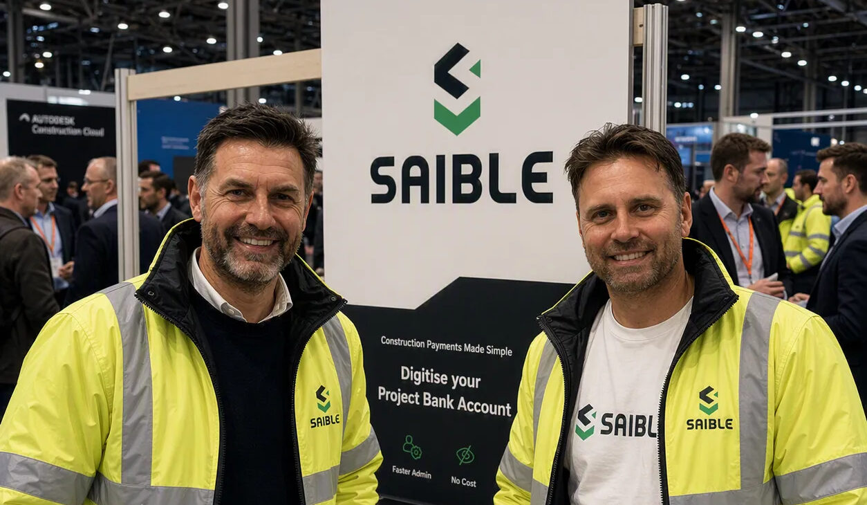 Two mean wearing high vis jackets in front of a Saible sign