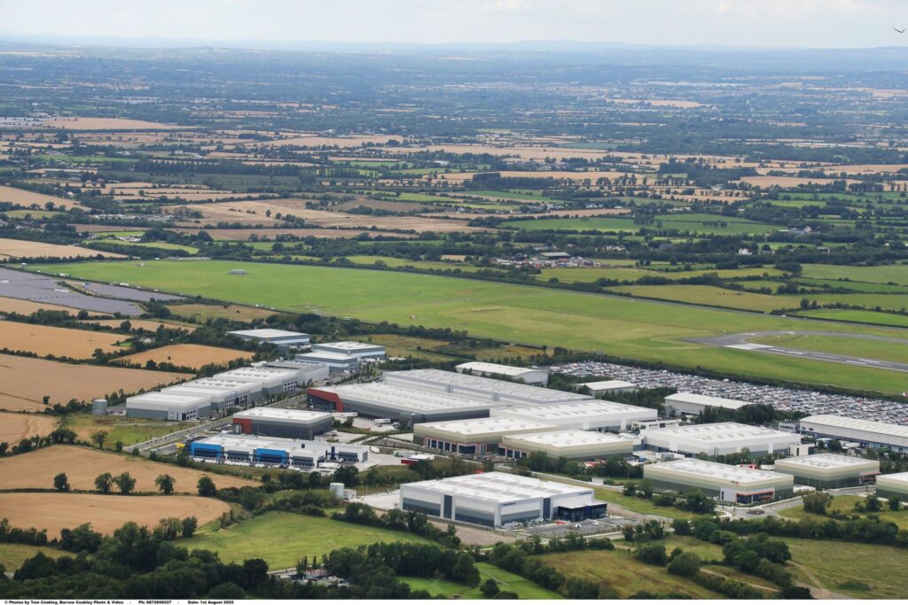 Aerial view of a series of industrial buildings surrounded by green fields