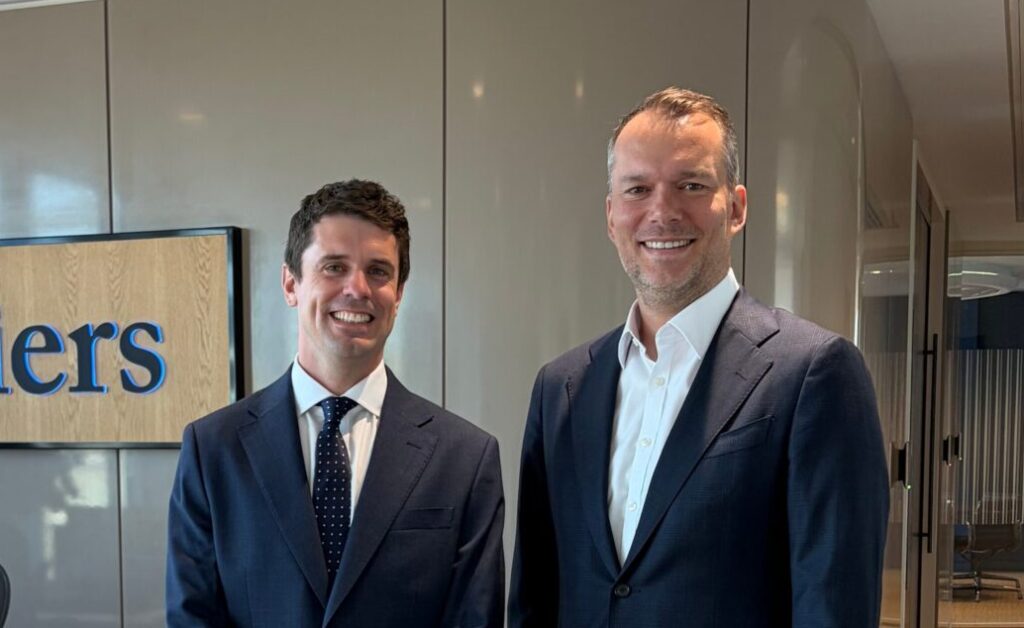Two smiling men wearing suits