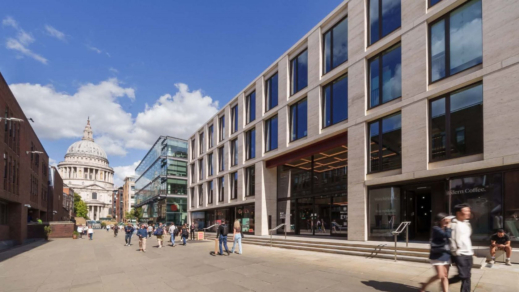 A low-rise office building with St Paul's cathedral looming large in the background