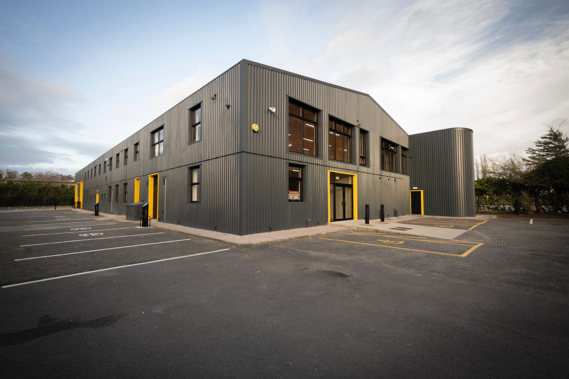 A modern low rise industrial building with a black exterior