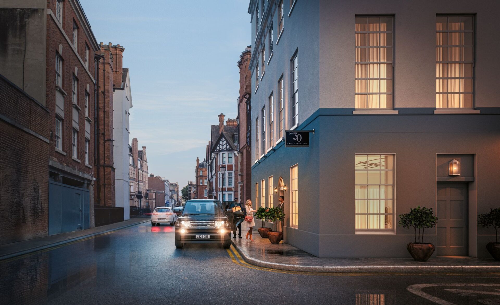 A series of buildings at dusk with a car parked on a corner