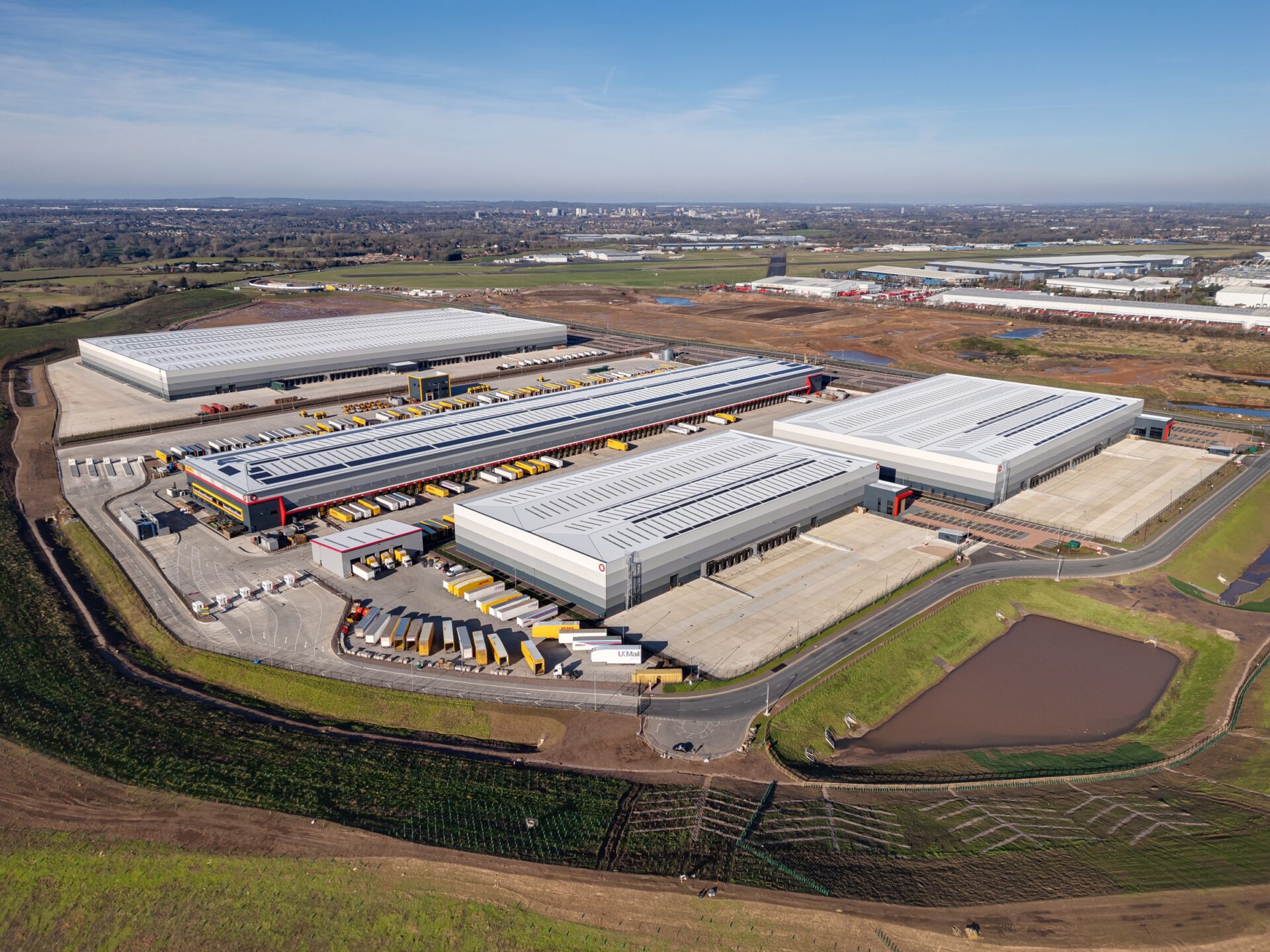 Aerial view of a series of new large industrial buildings surrounded by fields