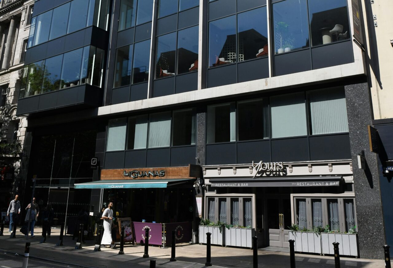 An office building with retail units on the ground floor and a main road in front