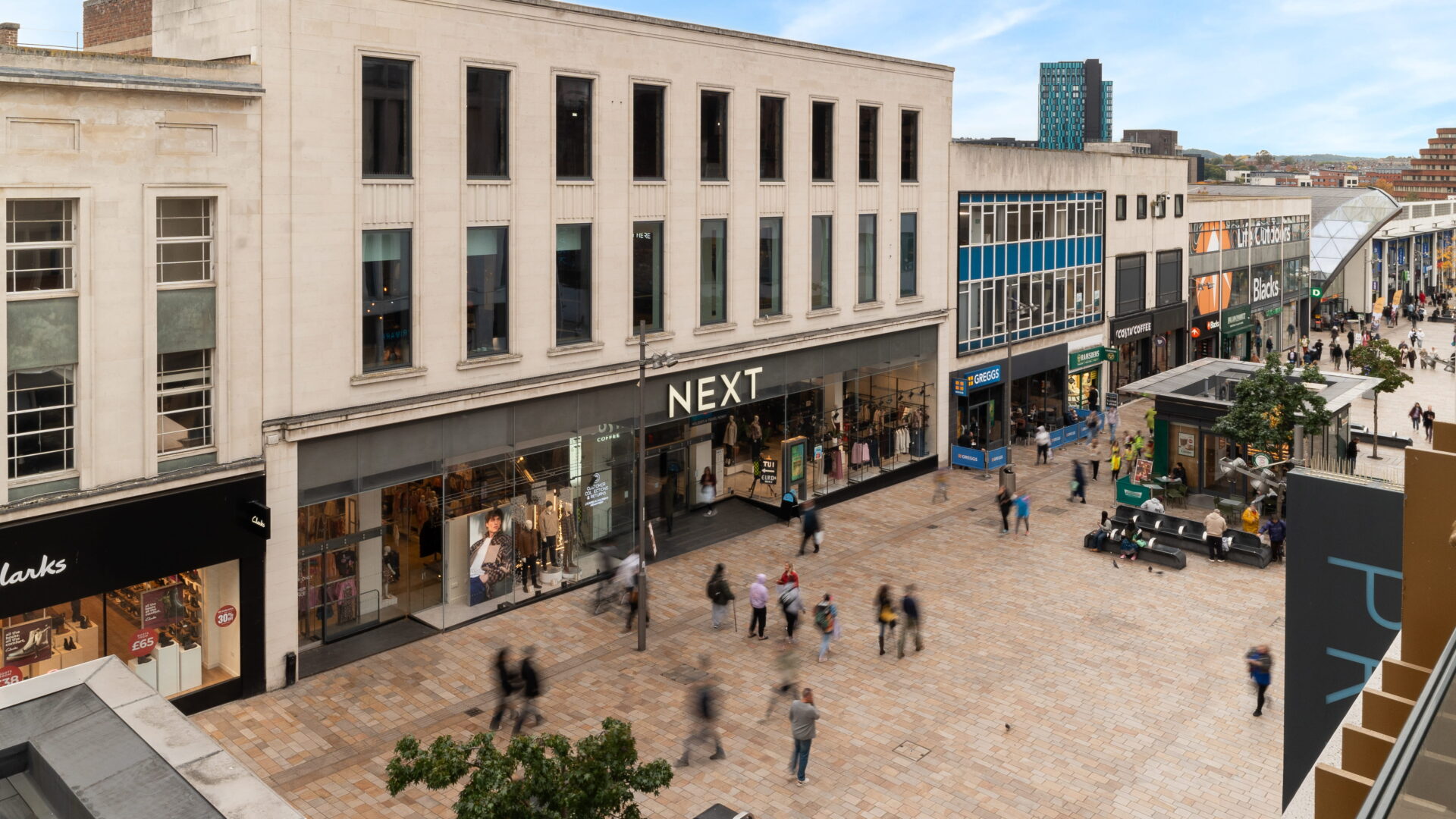 A pedestrianised high street featuring a large Next store