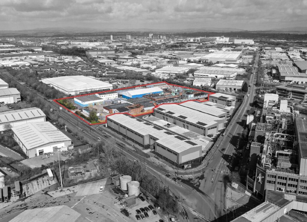 Black and white aerial view of Trafford Park industrial estate in Manchester with an area outlined in red shown in full colour