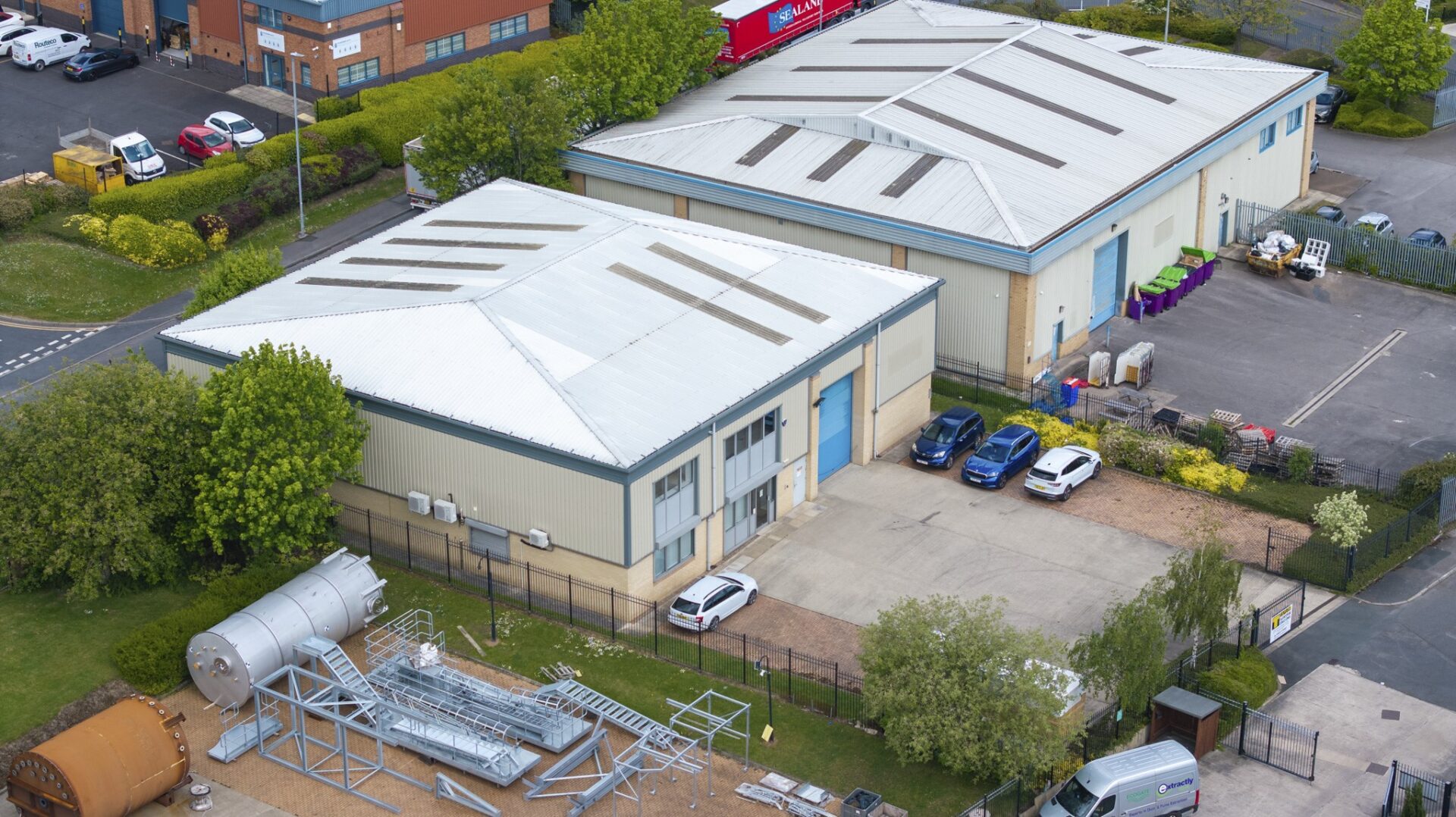 Aerial view of two industrial units with yard space and car parking to the front