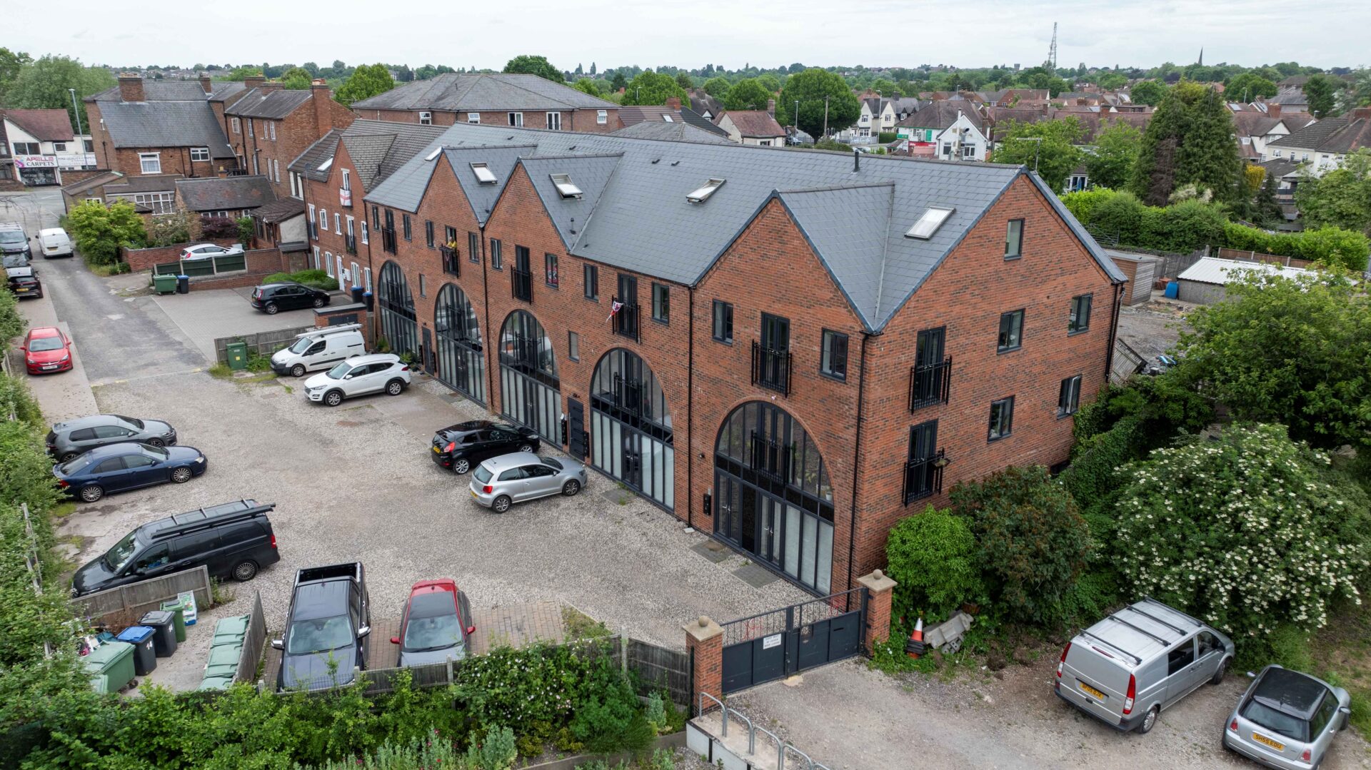 Aerial view of a brick built residential buildings with parking to the front and the side