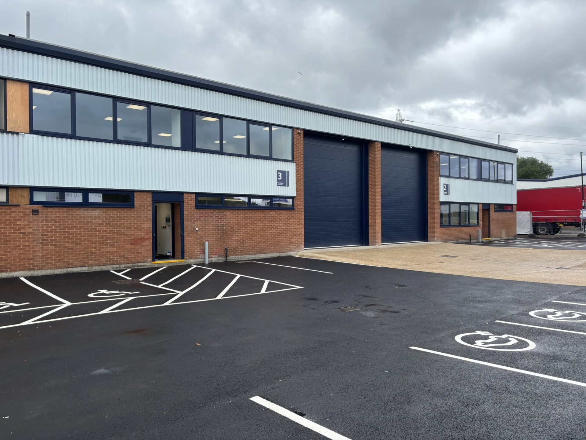 An industrial building with a parking area in front