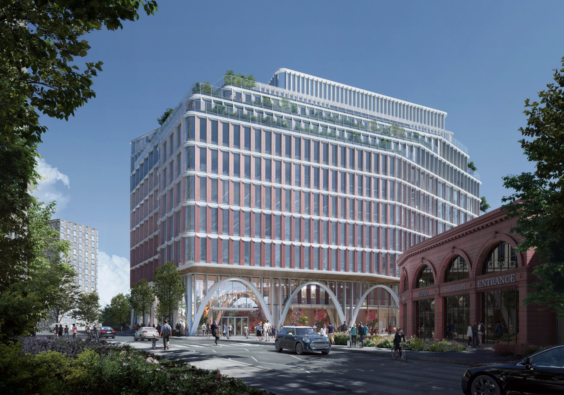 A modern office building featuring a glass and steel facade with a main road running in front