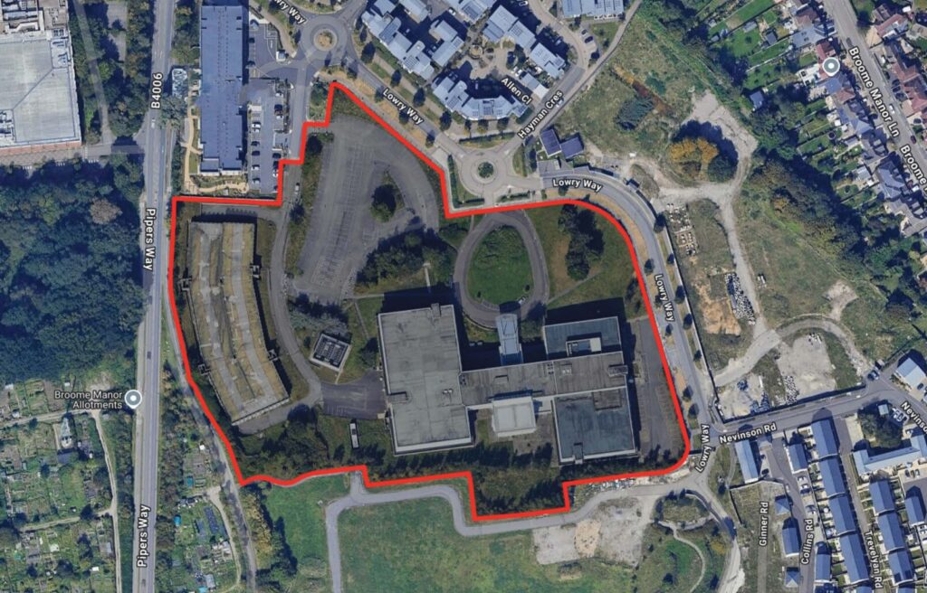 Aerial view of a development site outlined in red surrounded by housing