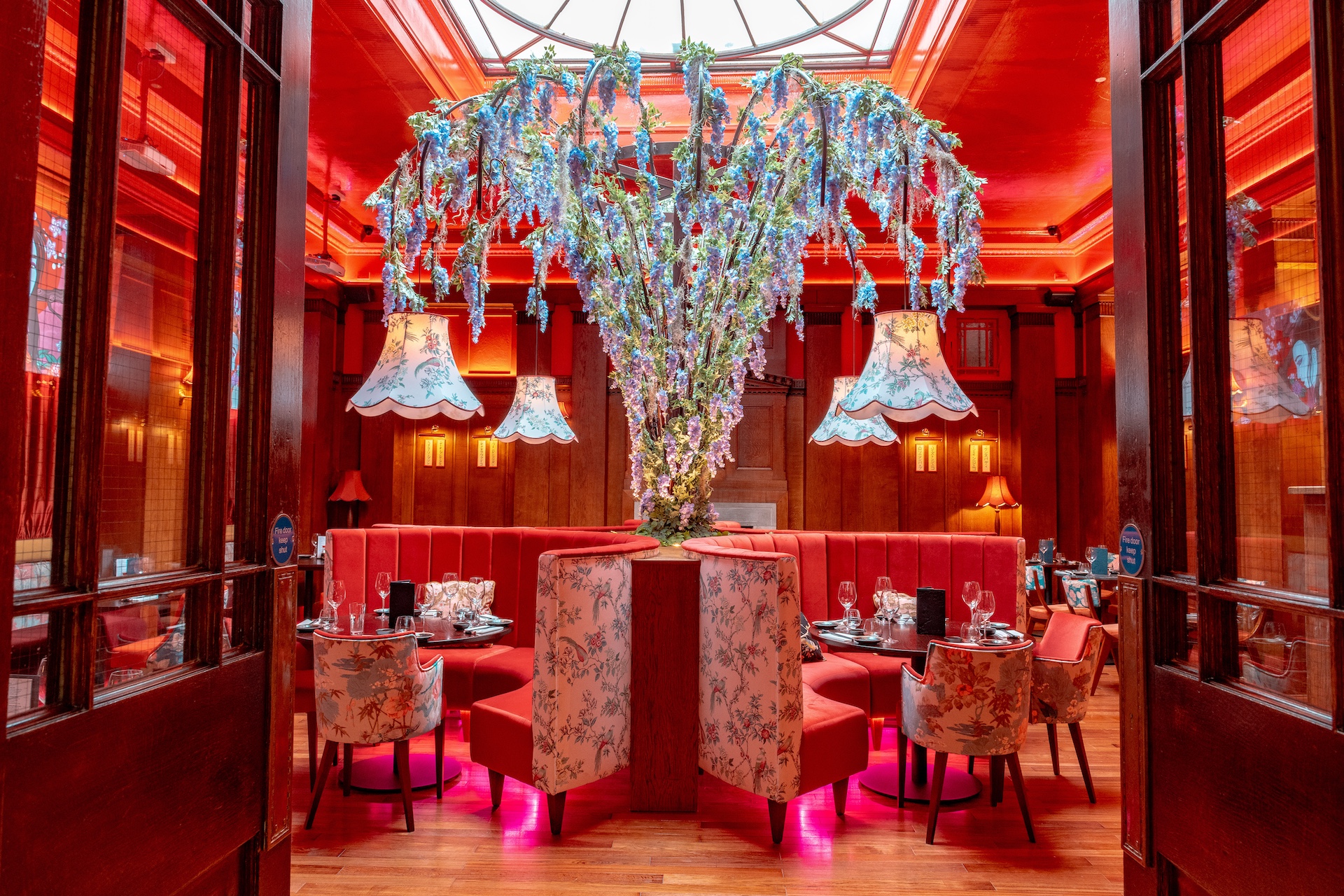 Luxurious interior of a restaurant featuring large chandeliers and red walls and furnishings