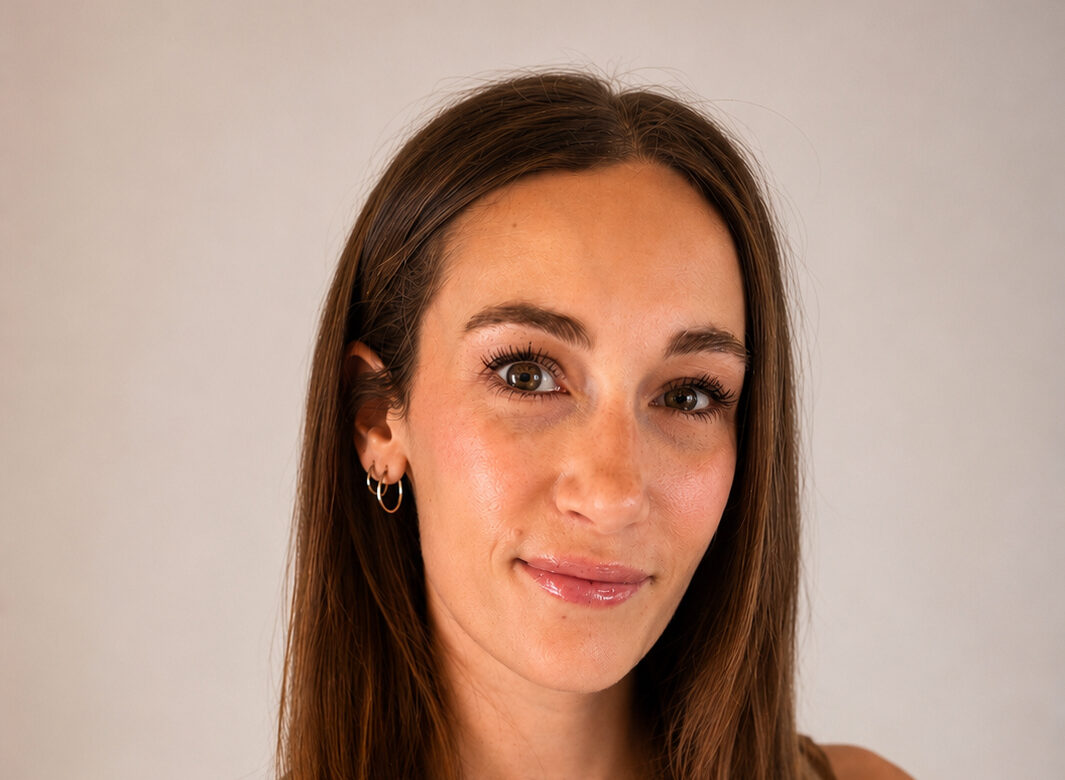 A woman with long brown hair wearing a sleeveless top