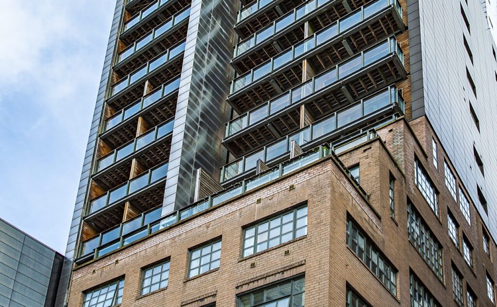 A large silver tower block above brick built lower floors