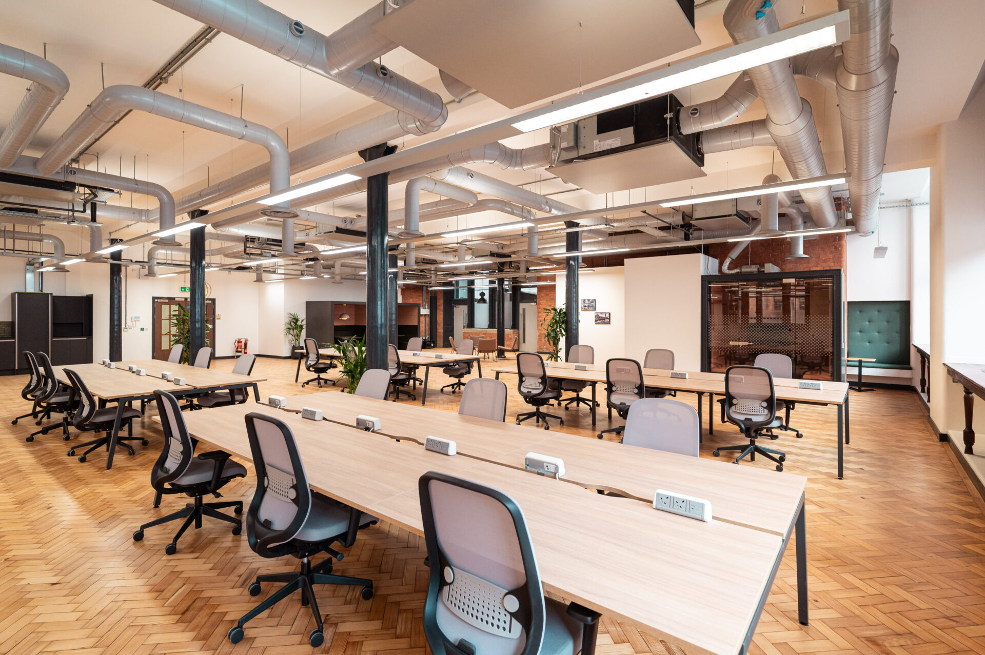 Interior of an office featuring lots of desks and chairs