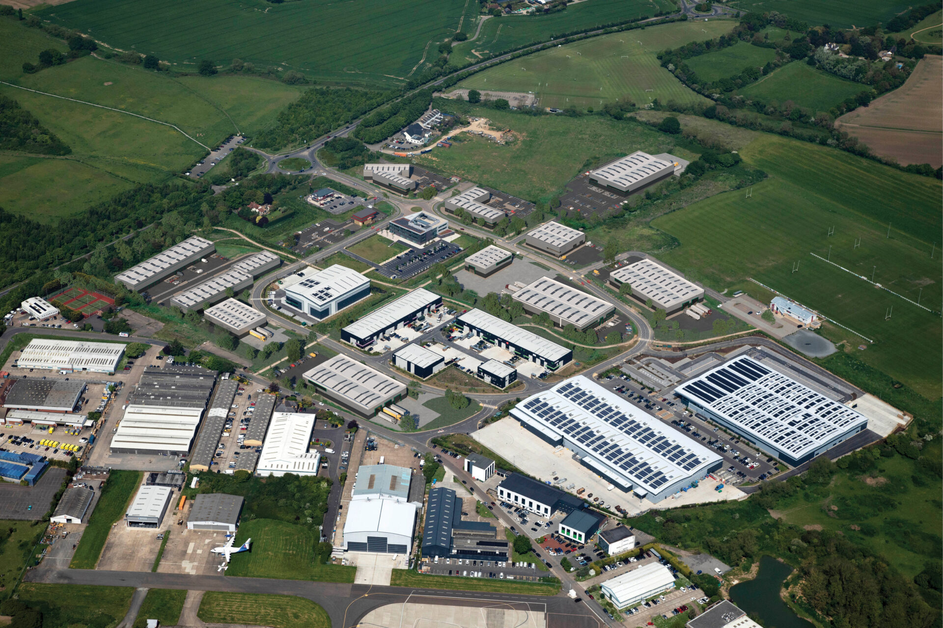 Aerial view of a series of large industrial buildings surrounded by fields