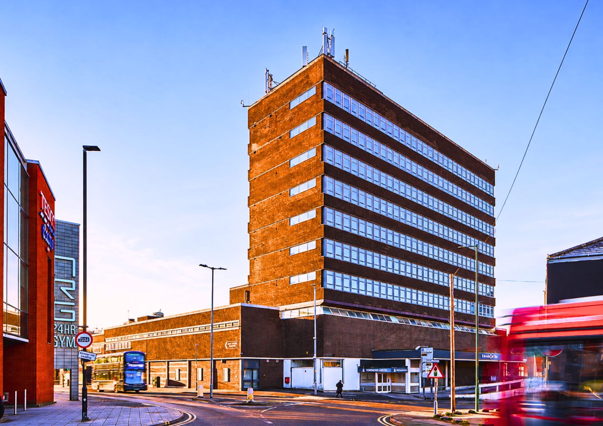 A seven-storey brick built office building with a road running in front