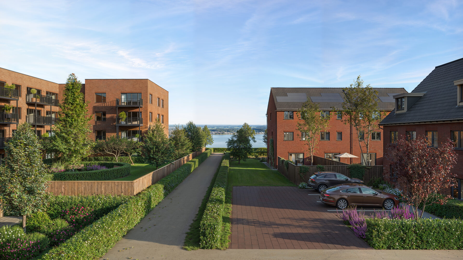 CGI image of a housing development featuring a range of different homes with a river in the background