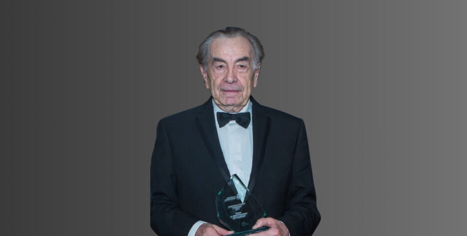 A man wearing a dark suit and a bow tie