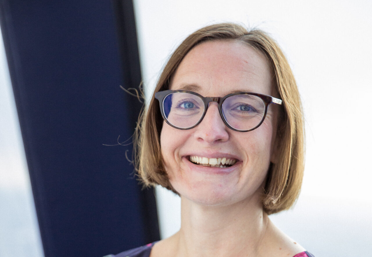Smiling woman with a brown bob wearing glasses