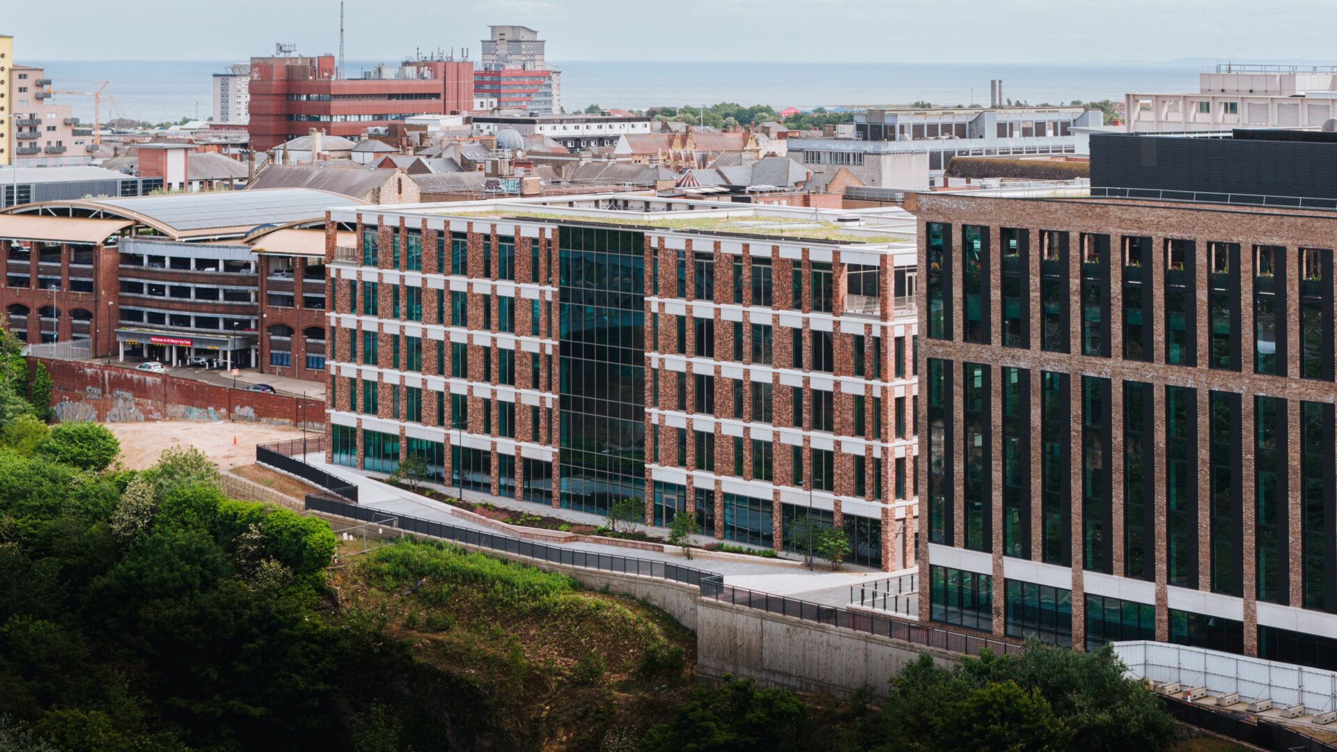 A series of relatively low rise glass and brick built buildings