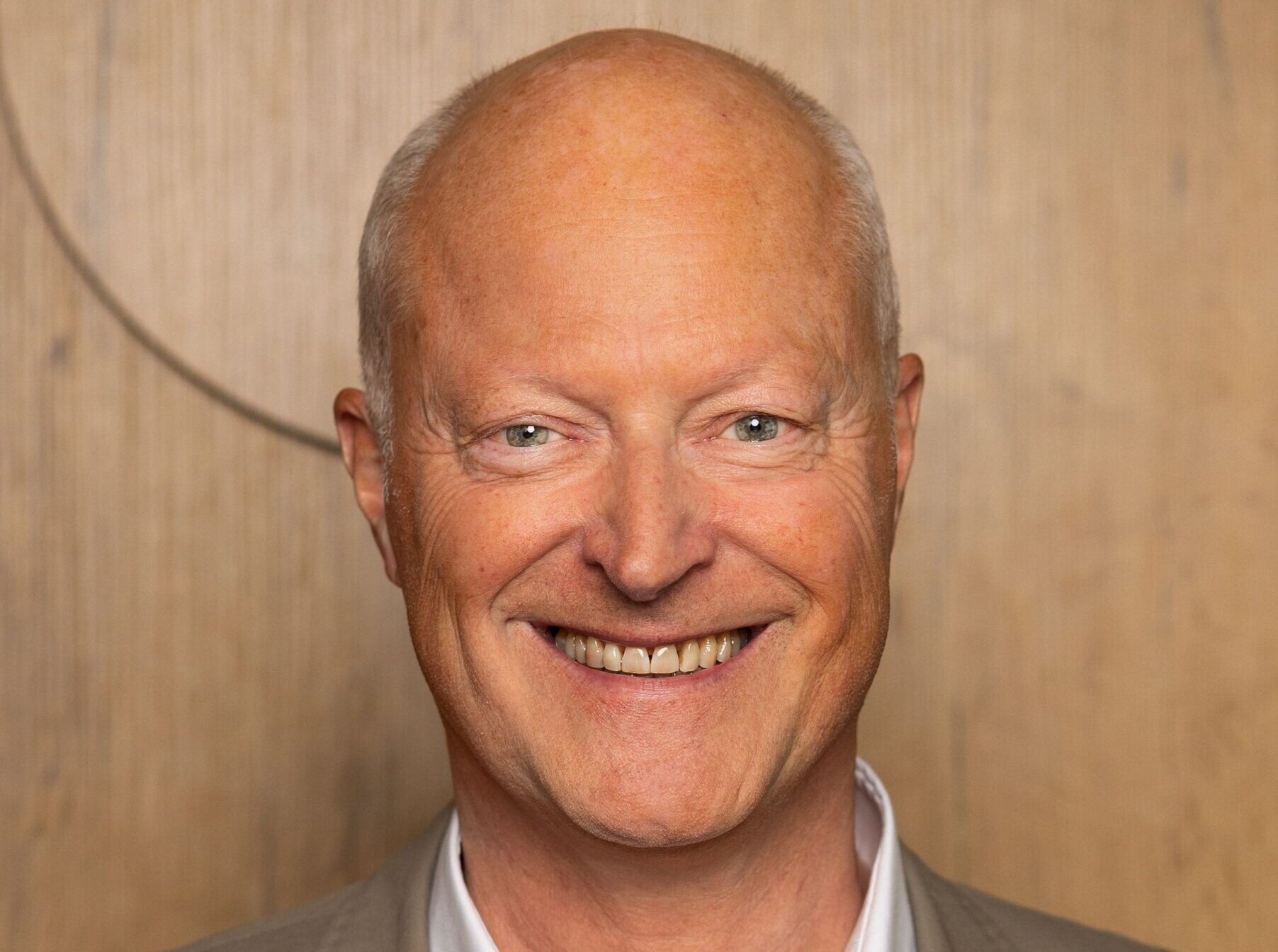 A smiling man wearing a suit jacket and shirt