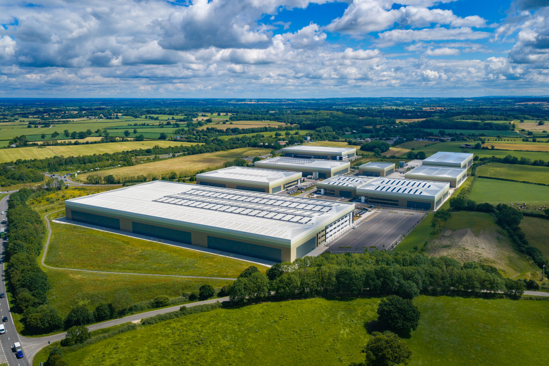 Aerial view of a series of warehouses surrounded by green fields