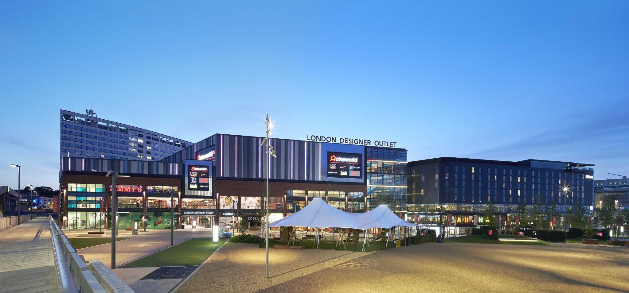Exterior of the London Designer Outlet centre at dusk