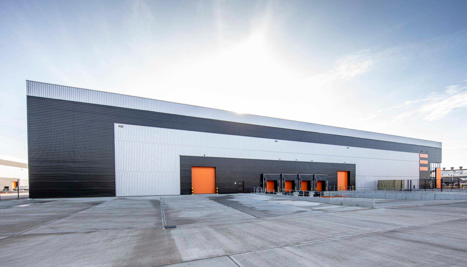 A large industrial building with a yard in front