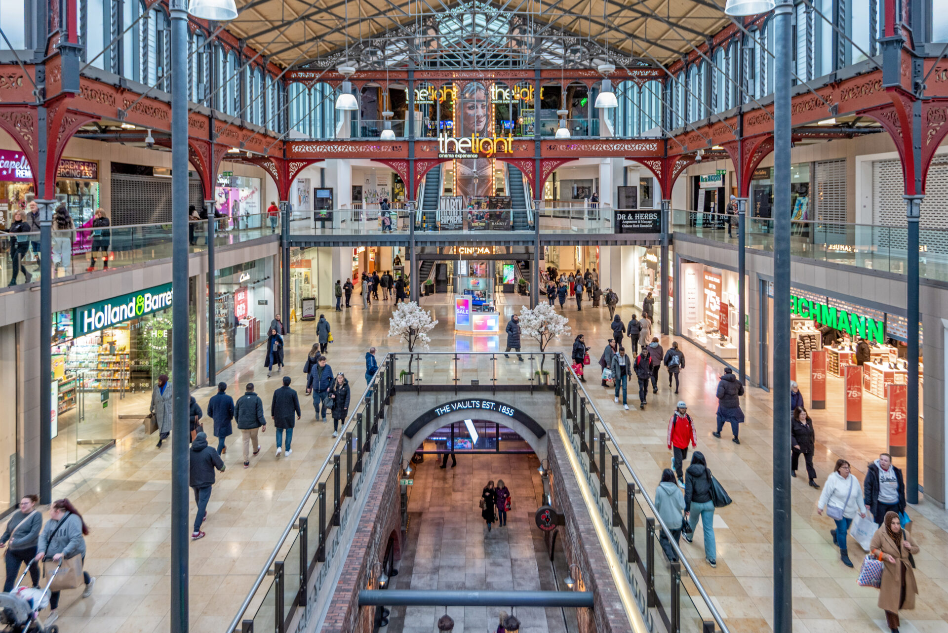 Interior of a shopping centre featuring lots of shops and shoppers