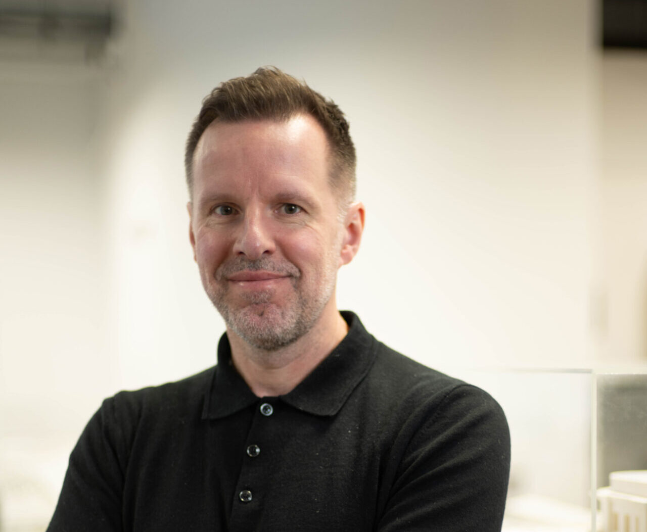 A man wearing a black shirt with his arms folded
