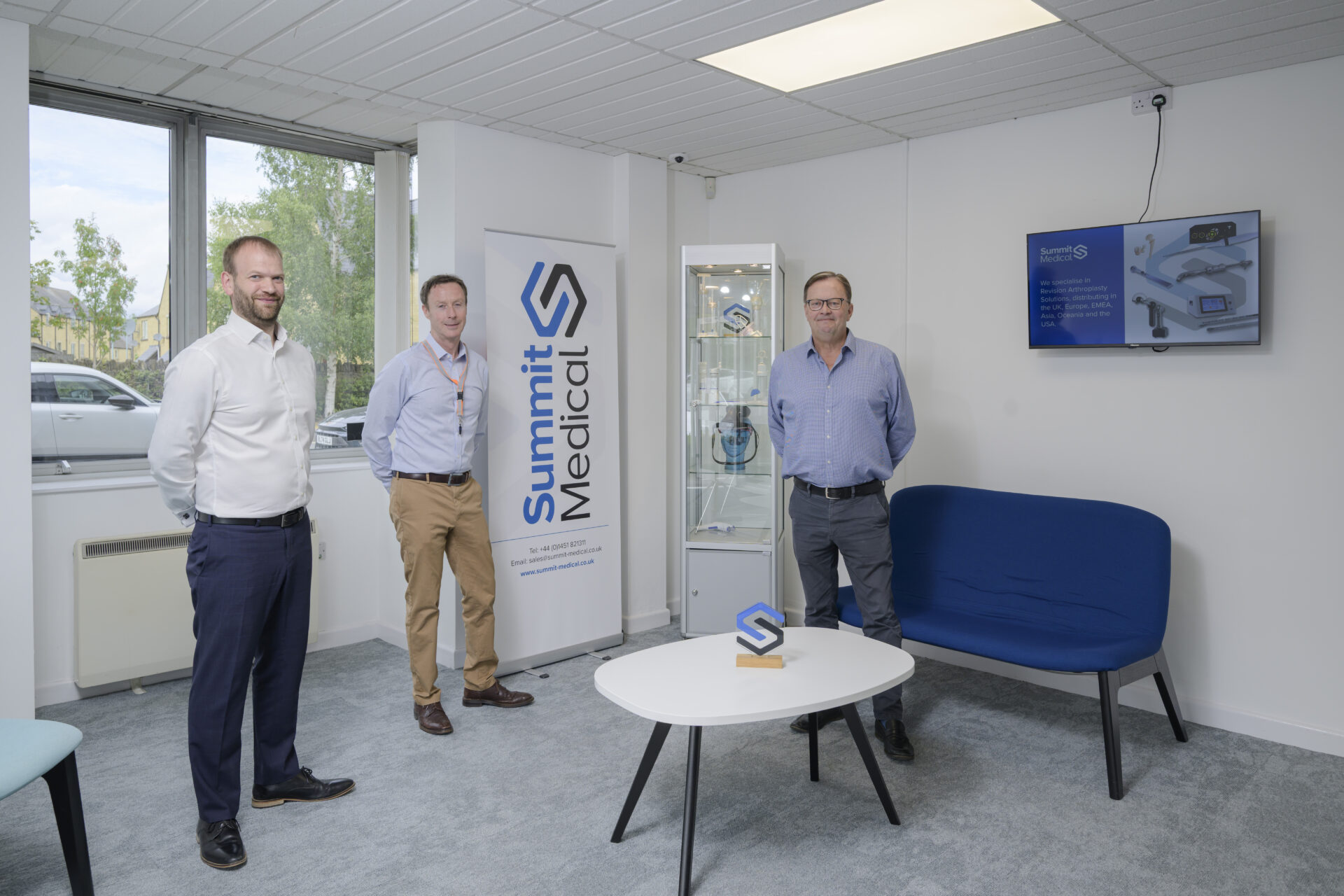 Three men standing in a white room