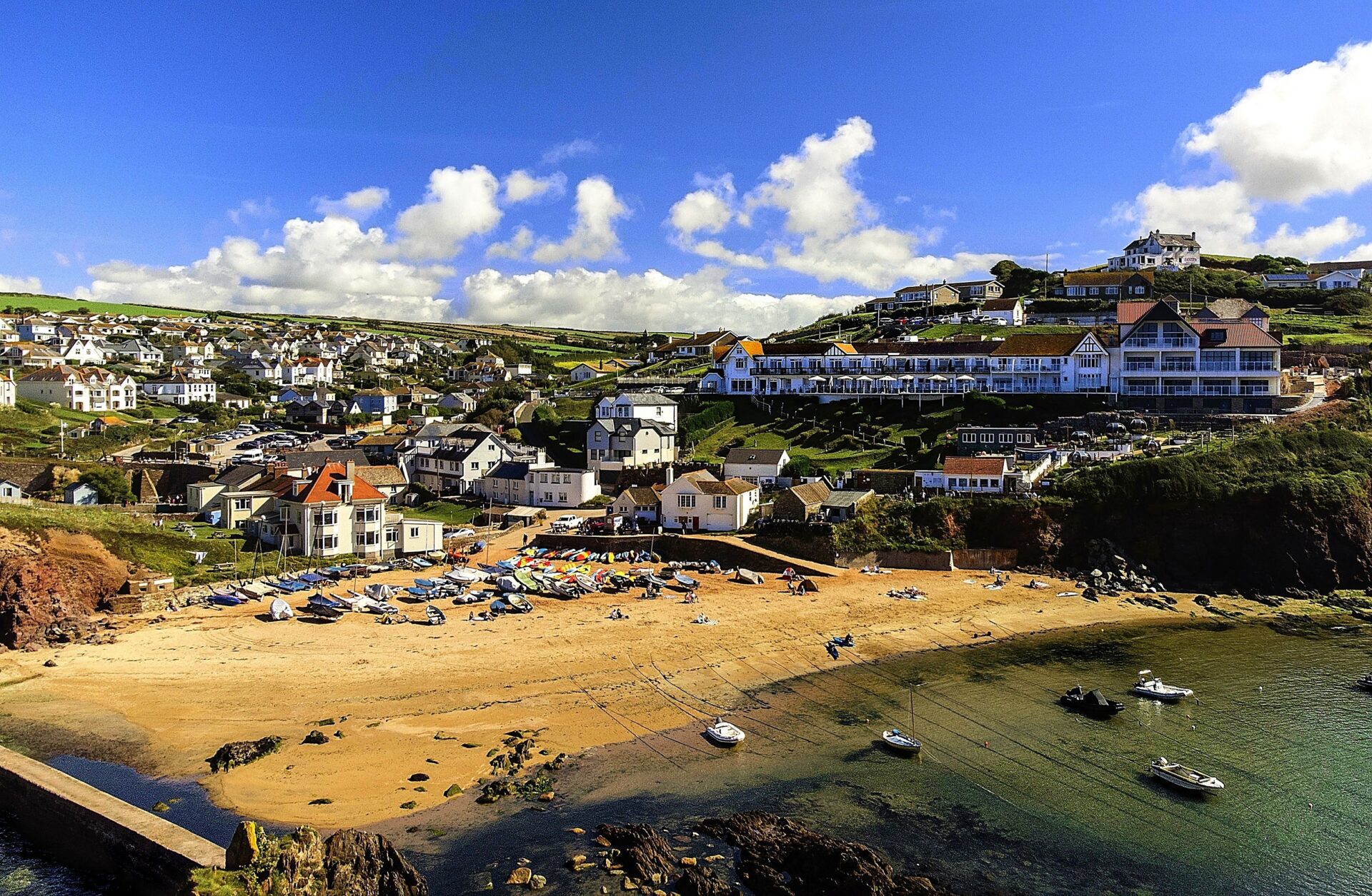 A bay in South Devon with the beach and sea in the foreground and buildings on the hillside