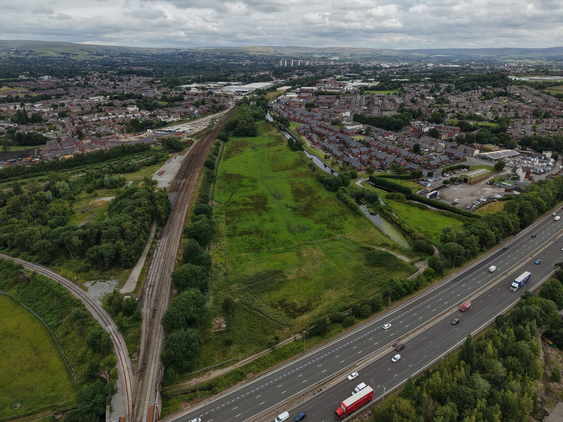A plot of green lands surrounded by roads and housing