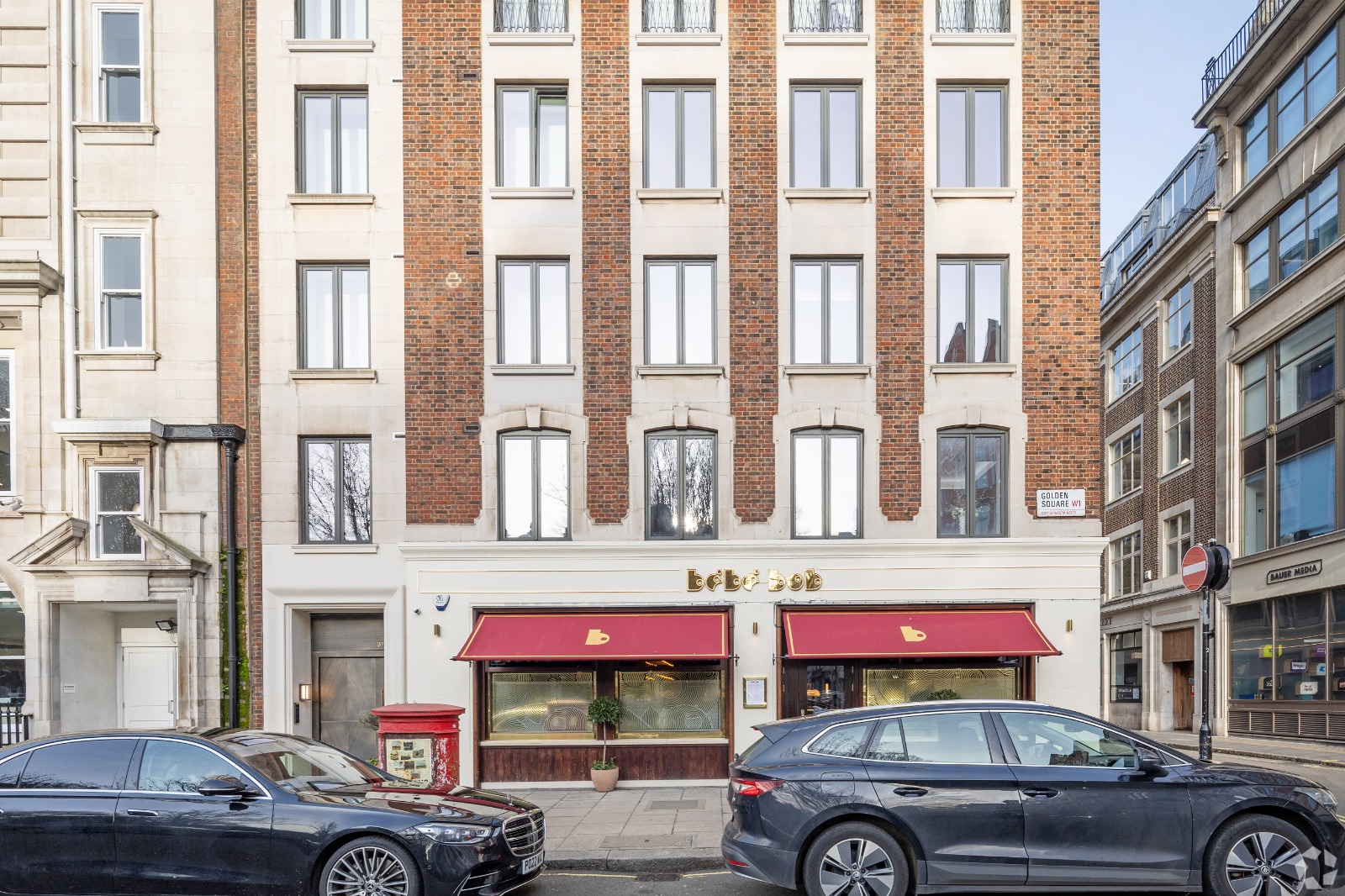 Exterior of a luxury apartment building with cars parked in front