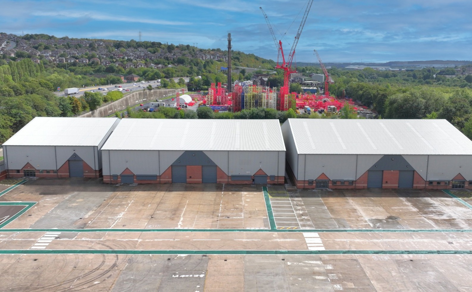 Aerial vow of a row of industrial units with cranes and other machinery in the background