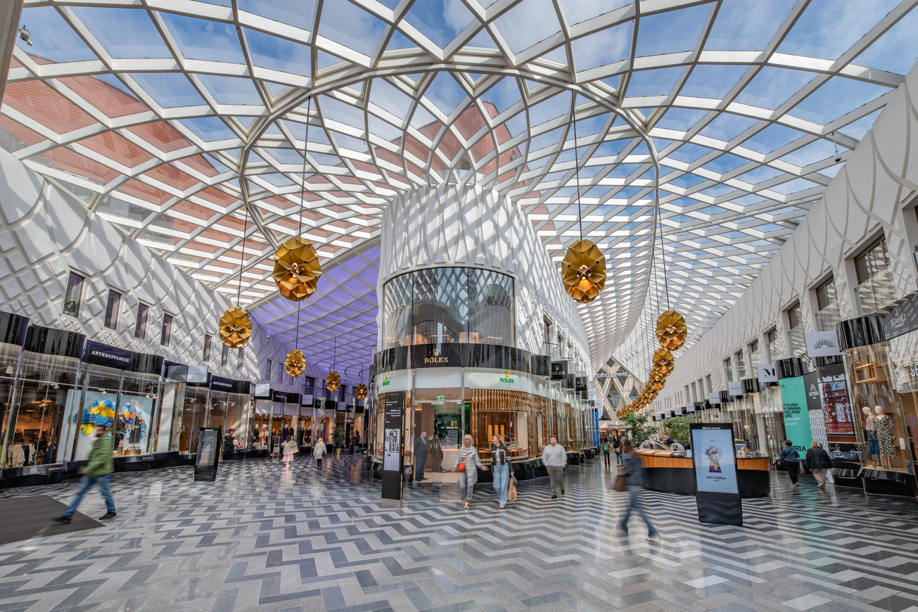 Interior of a modern shopping centre with a large glazed roof