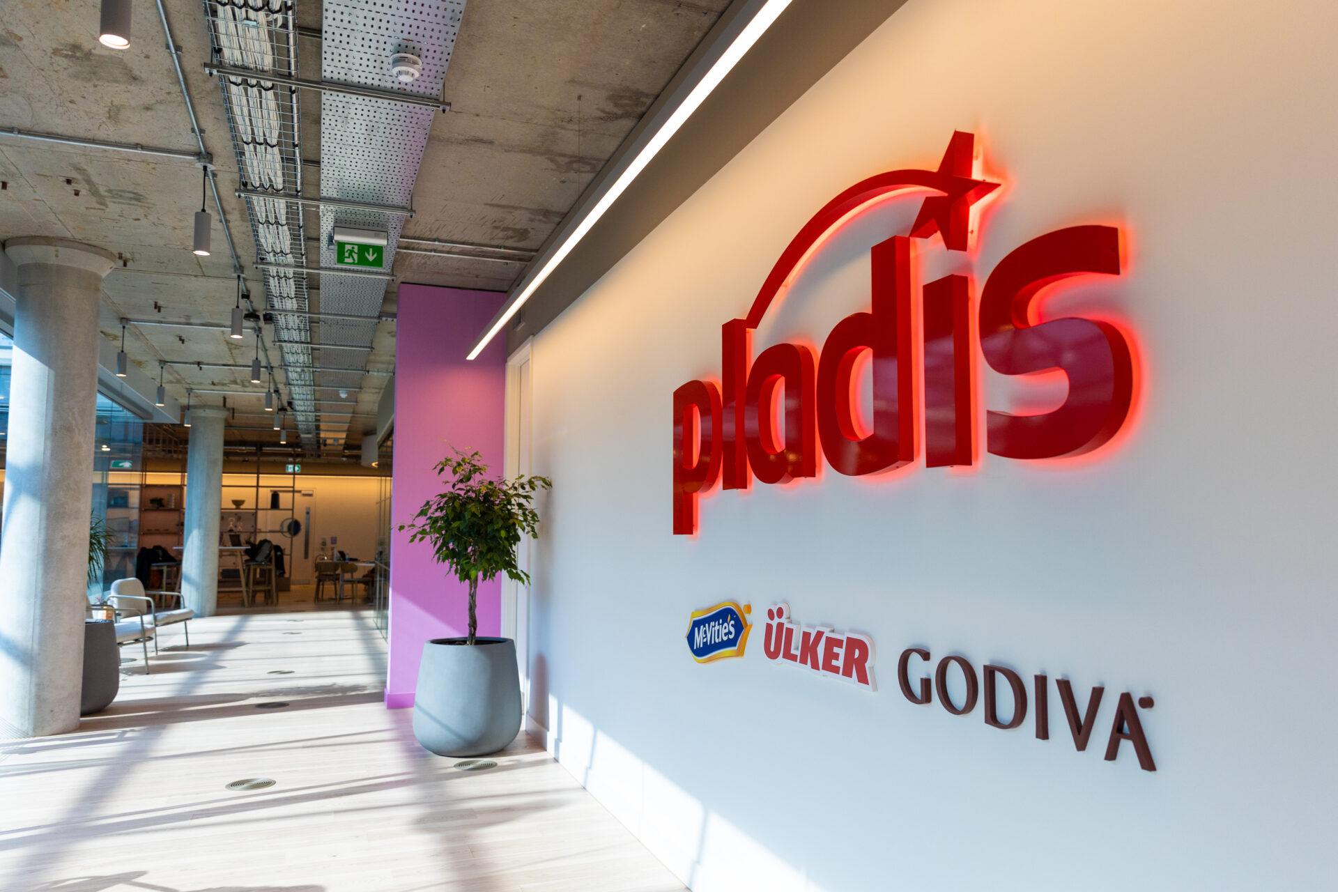 A white wall with a red Pladis logo on it