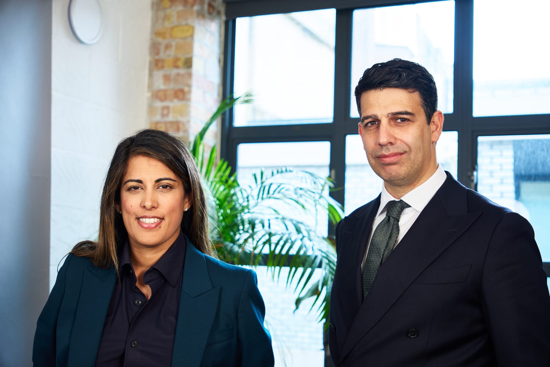 Sonia Gill and Paul Dodds of DG Capital Partners pose together in an office
